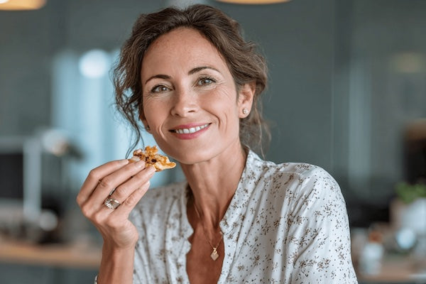 Woman snacking on piece of chicken