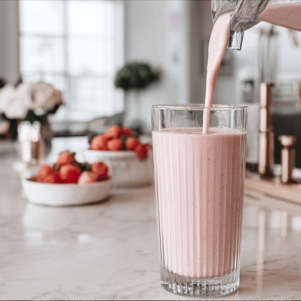 Eve Biology Strawberry shake being poured into a glass with a kitchen background