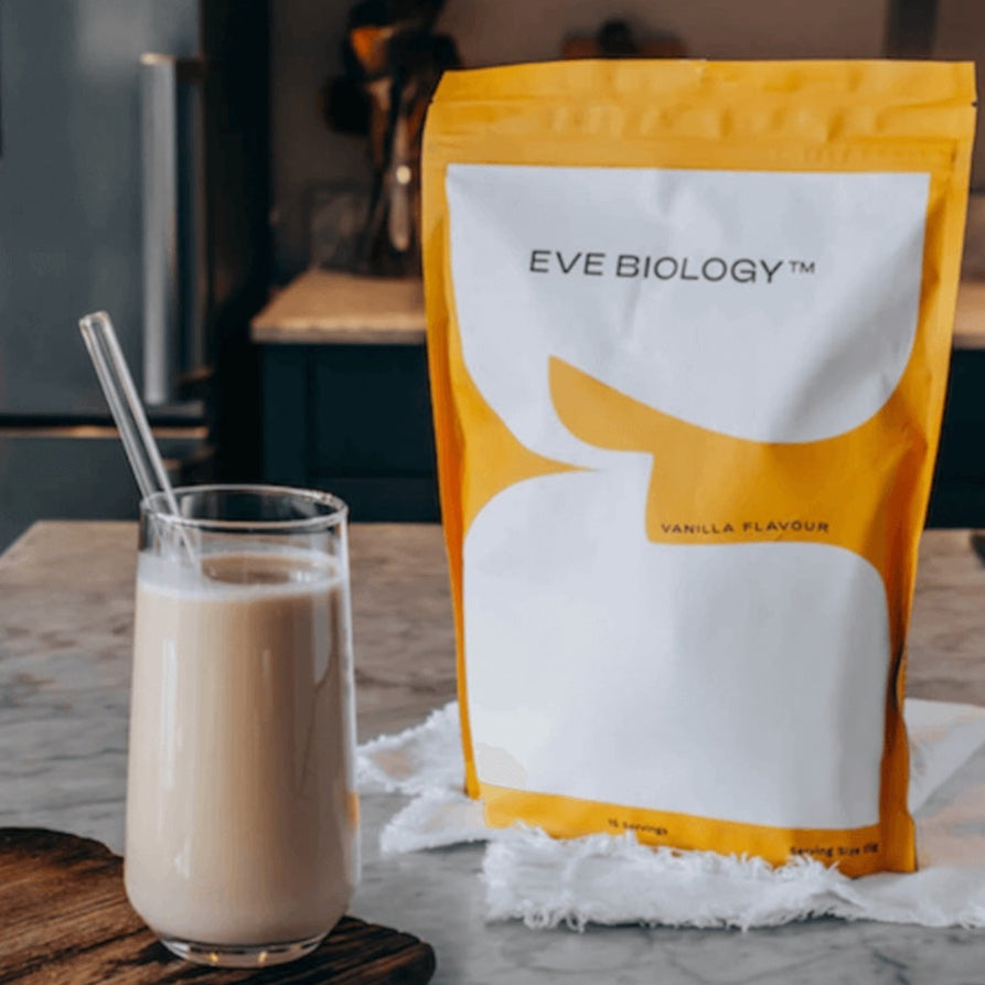Eve Biology vanilla-flavored weight loss meal replacement pouch with a glass of the product on a marble surface.