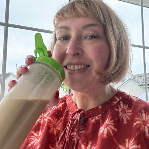 Woman in a pink blouse drinking a shake