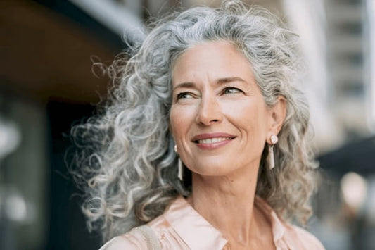 Woman long grey wavy hair pink blouse