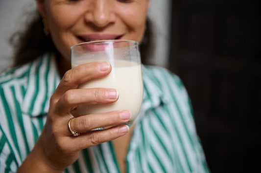 woman in a striped shirt holding a vanilla shake
