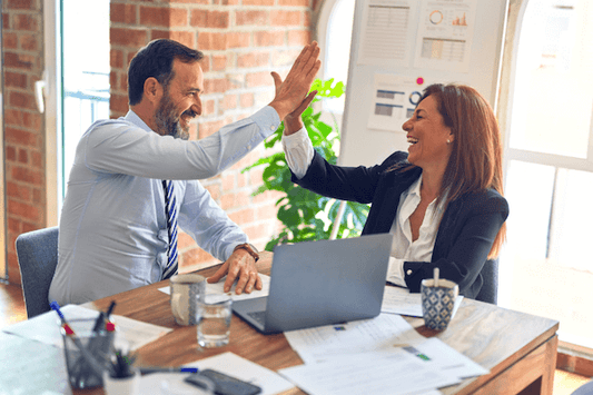 Mature woman celebrating at work 