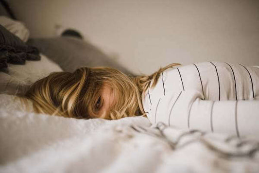 Woman lying in bed fully clothed