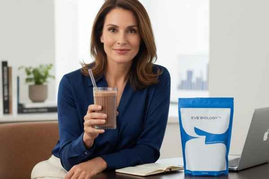 Woman in blue blouse drinking a shake at work