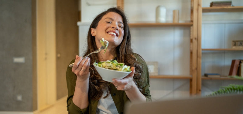 Woman eating lunch at work, green jacket
