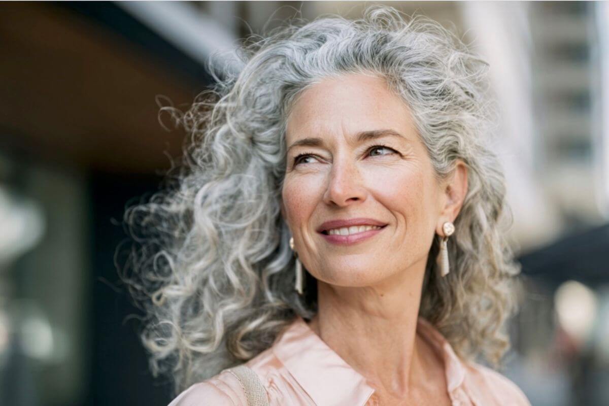 Woman with gray hair smiling outdoors