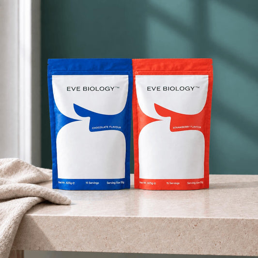 Two stand-up pouches of Eve Biology protein powder sit on a light stone countertop. The left pouch is blue and labeled chocolate flavor, and the right pouch is red and labeled strawberry flavor.