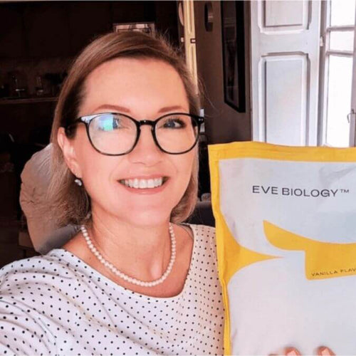 Woman holding a package of Eve Biology in a kitchen setting