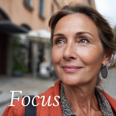 woman in an orange jacket with silver earrings