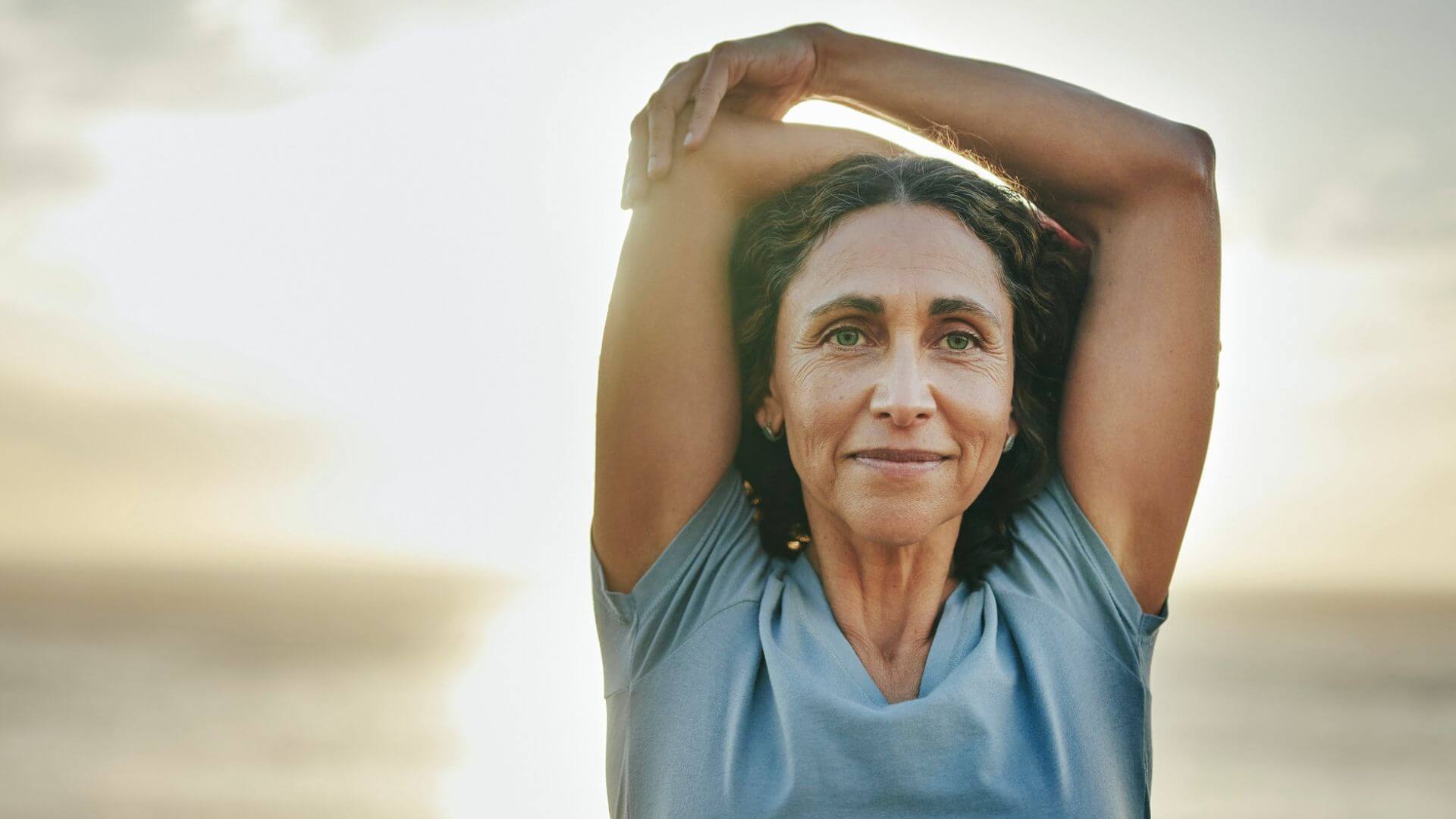 Woman stretching with a blurred natural background