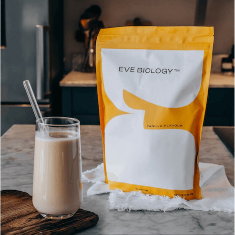 Eve Biology vanilla-flavored weight loss meal replacement pouch with a glass of the product on a marble surface.