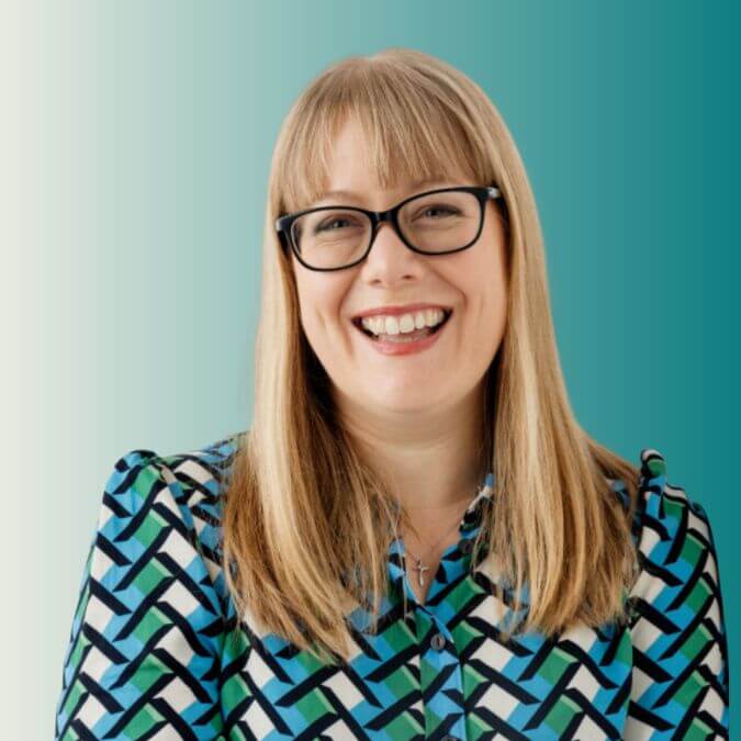 Nutritionist with glasses and a patterned shirt against a teal background
