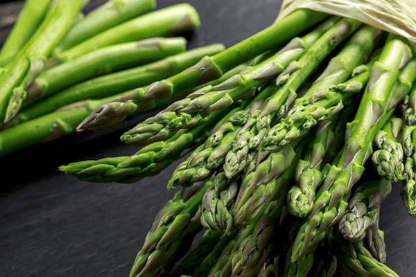 Bunch of green asparagus on a dark surface