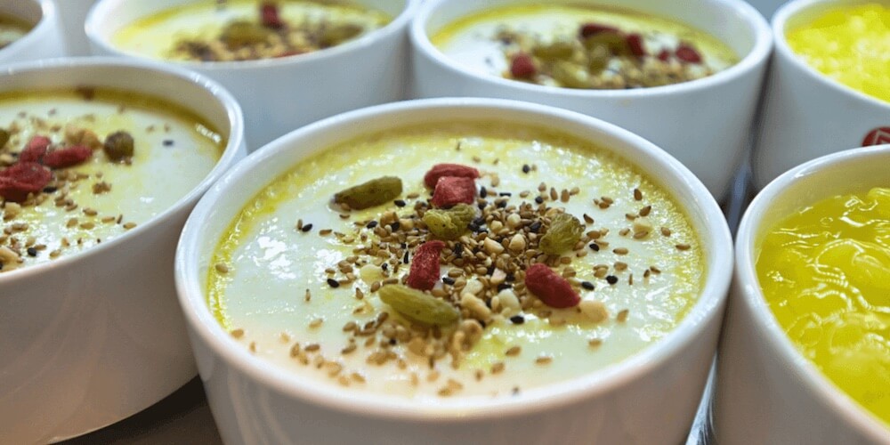 Creamy desert in ramekins with berry and nuts topping