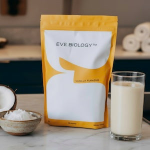 Eve Biology product packaging with a glass of vanilla-flavored drink on a table.