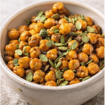 Bowl of roasted chickpeas with pumpkin seeds on a textured surface