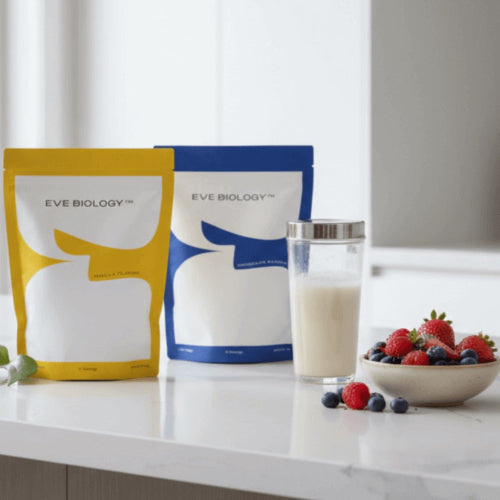 Two Eve Biology packages on a counter with a glass of milk and bowl of berries.