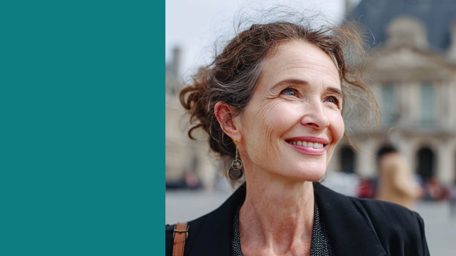 Woman with a smile in front of a blurred architectural background