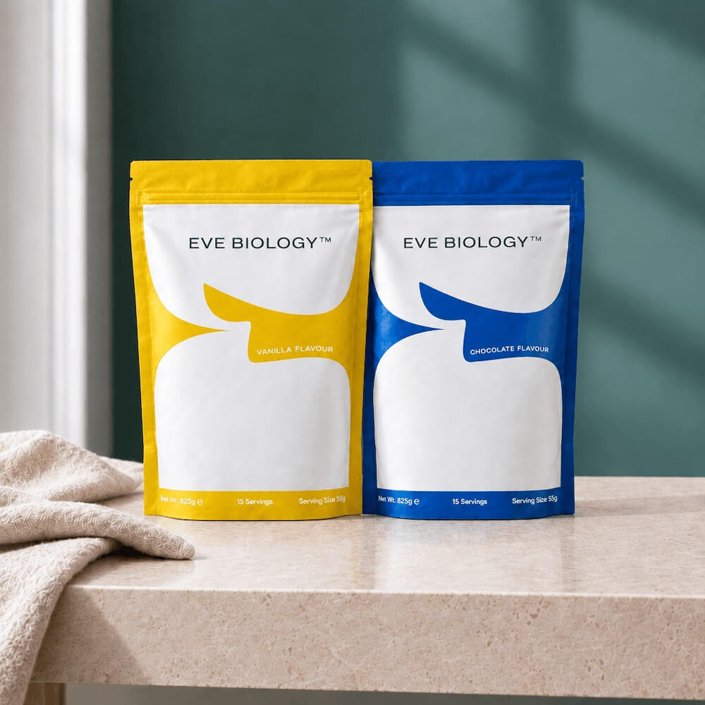 Two stand-up pouches of Eve Biology protein powder sit on a beige countertop. The left pouch is yellow with a white graphic and reads Vanilla Flavour; the right pouch is blue with a white graphic and reads Chocolate Flavour.